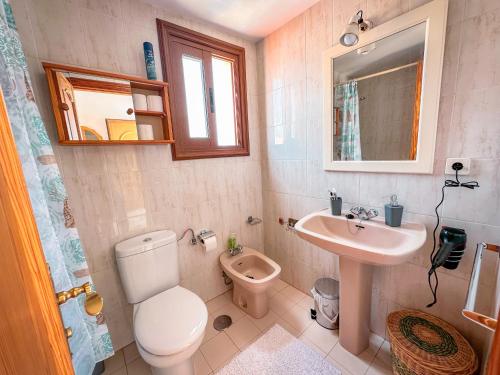 un bagno con un water, un lavandino e uno specchio di Apartment 219 - Amarilla Golf a San Miguel de Abona