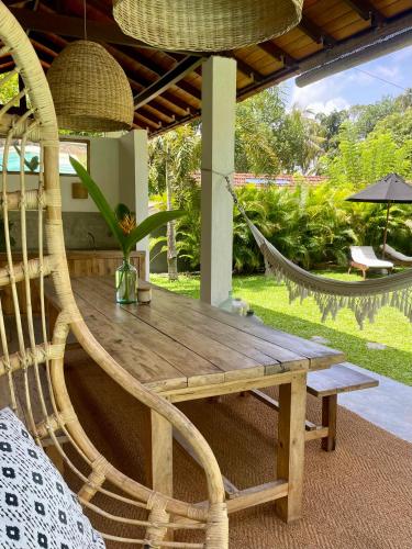 a wooden table with a bench and a hammock at Kanferri Villa in Ahangama