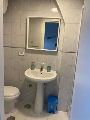 a bathroom with a sink and a toilet and a mirror at C sta o mar for in Naples