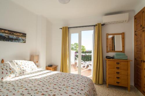 - une chambre avec un lit et une porte coulissante en verre dans l'établissement Tetuan 7 Oasis Properties, à Nerja