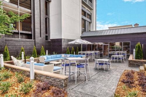 a patio with tables and chairs outside of a building at Courtyard by Marriott Nashville Vanderbilt West End in Nashville