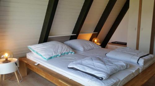 a bed with two pillows on top of it at Ferienpark Fedderwardersiel in Fedderwarderdeich