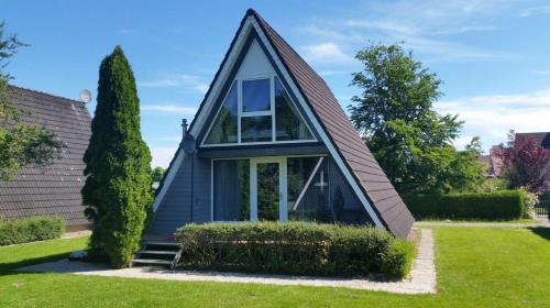 a small house with a gambrel roof at Ferienpark Fedderwardersiel in Fedderwarderdeich