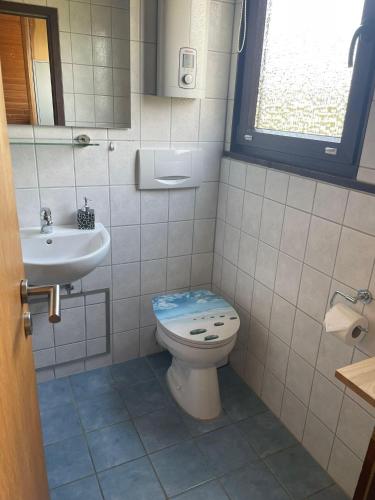 a bathroom with a toilet and a sink at Ferienpark Fedderwardersiel in Fedderwarderdeich