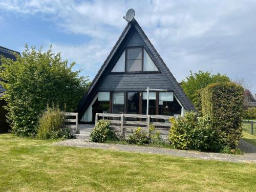 a black house with a gambrel roof at Ferienpark Fedderwardersiel in Fedderwarderdeich