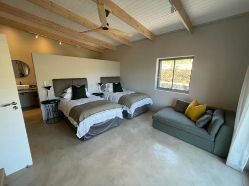 1 dormitorio con 2 camas y sofá en Windon vineyard farmhouse, en Stellenbosch