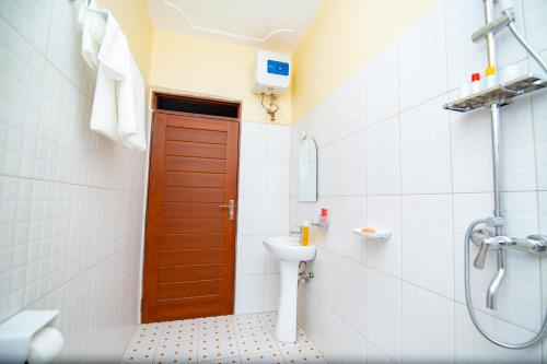 ein Bad mit einem WC und einer braunen Tür in der Unterkunft Tanta Guesthouse in Kira