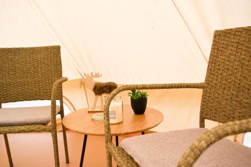 um quarto com cadeiras, uma mesa e uma tenda em Glamping Bolmen, Seaview, free canoe em Odensjö