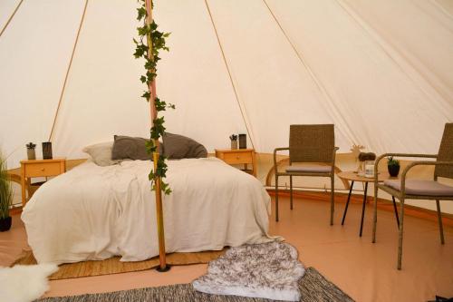 a bedroom with a bed in a tent at Glamping Bolmen, Seaview, free canoe in Odensjö