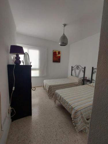 a bedroom with two beds and a lamp in it at El Mirador in Prado del Rey