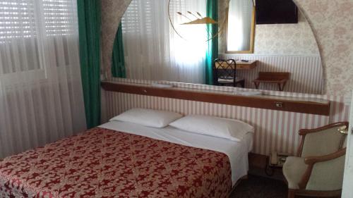 a small bedroom with a bed and a mirror at Grande Albergo Abruzzo in Chieti