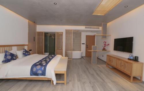 a bedroom with a large bed and a television at Cozy Boutique Hotel in Zhangjiajie