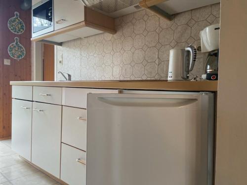a kitchen with white cabinets and a white refrigerator at Ferienpark Fedderwardersiel in Fedderwarderdeich