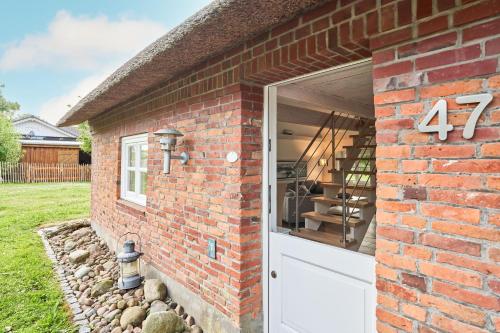 a brick building with a white garage door at Reetdachhaus Haubarg-Kieker in Simonsberg