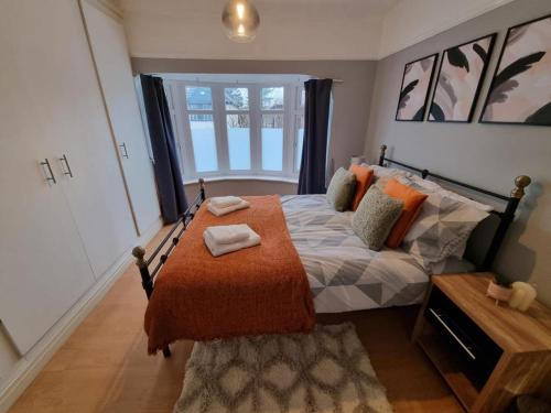 a bedroom with a bed with an orange blanket at Comfortable Business and Family Home in Manchester