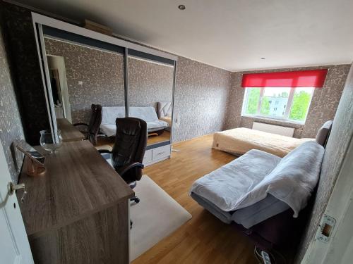 a room with a bed and a desk and a bedroom at Vienības in Krāslava
