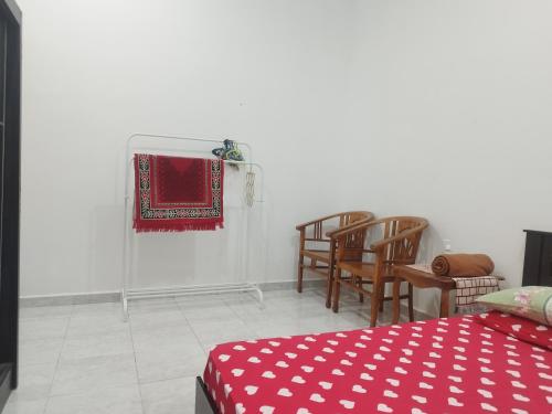 a room with a bed and chairs and a red blanket at Homestay Batu Pahat, BUSHRA in Batu Pahat