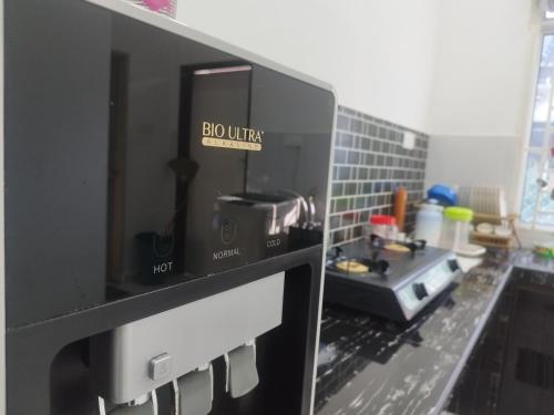 a microwave oven with a sign that reads boom kitchen at Bushra Guest House, Batu Pahat in Batu Pahat