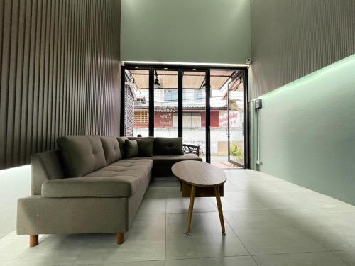 a living room with a couch and a table at Comfort Zone Hostel @ Tha Pae in Chiang Mai