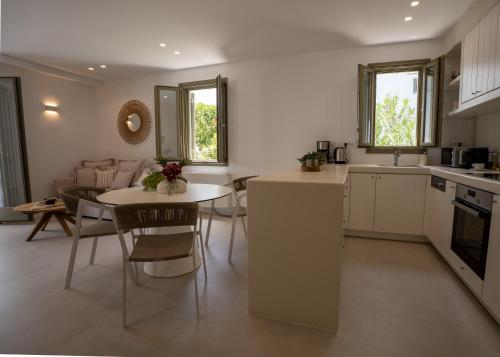 a kitchen and living room with a table and chairs at Paros Breeze Luxury Villa in Drios