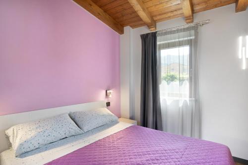 - une chambre avec un lit violet et une fenêtre dans l'établissement Agriturismo il Borgo - Rosmarino, à Villanova dʼAlbenga