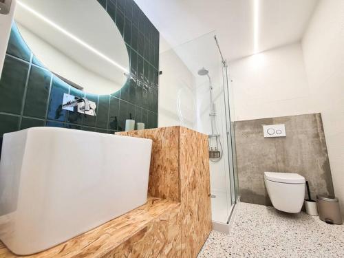 een badkamer met een toilet en een glazen douche bij green guest house. Figueira da Foz in Figueira da Foz