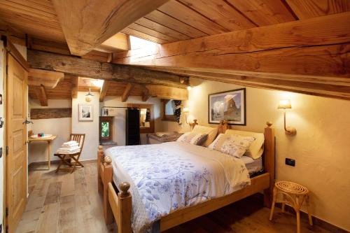 een slaapkamer met een groot bed en houten plafonds bij Chalet 1175 in Arvier