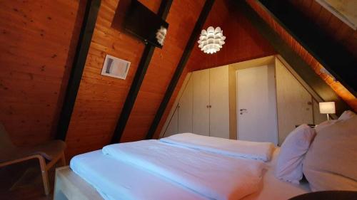 a bedroom with a white bed in a attic at Ferienpark Fedderwardersiel in Fedderwarderdeich