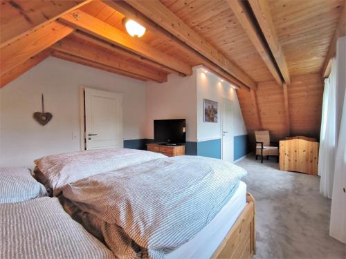 a bedroom with a large bed in a room with wooden ceilings at Holly Haus in Tarp