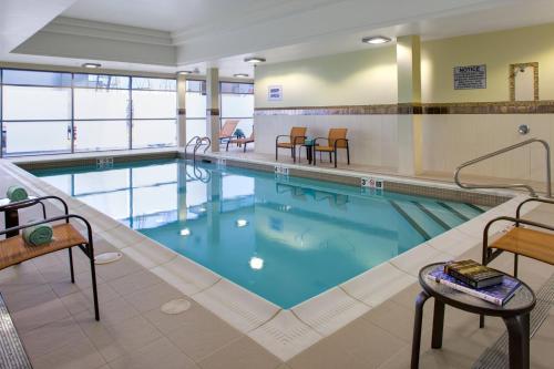 a pool in a hotel with chairs and a table at Courtyard by Marriott London in London