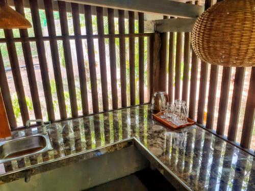 a kitchen counter with a sink and glasses on it at Neem Jay Beach Resort in Tangalle