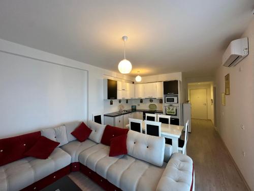 a living room with a white couch and a kitchen at Appartamento Saranda in Sarandë