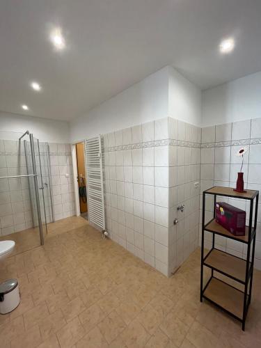 a bathroom with white tiled walls and a shower at Altstadtmoment in Blankenburg