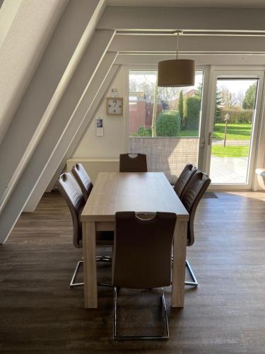 a dining room with a wooden table and chairs at Ferienpark Fedderwardersiel in Fedderwarderdeich