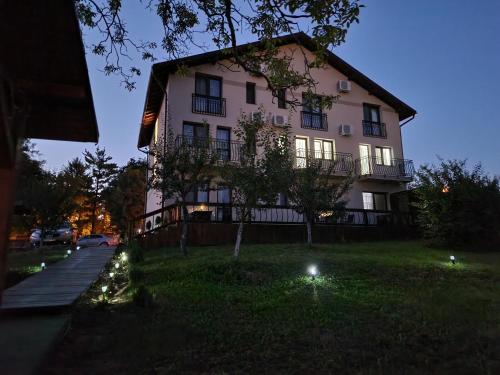 a large white building with lights in the grass at Bella Vista Turda in Turda