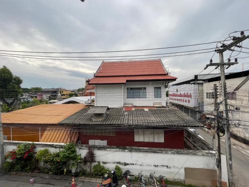 uma casa com um telhado vermelho no topo de um edifício em Comfort Zone Hostel @ Tha Pae em Chiang Mai