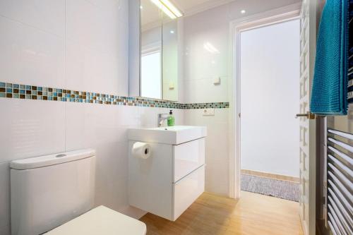 a white bathroom with a toilet and a sink at Las Palmas 2a Oasis Properties in Nerja