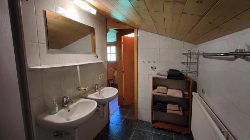 a bathroom with two sinks and a mirror at Sonnenglück Chalet WILD272 in Wildschönau