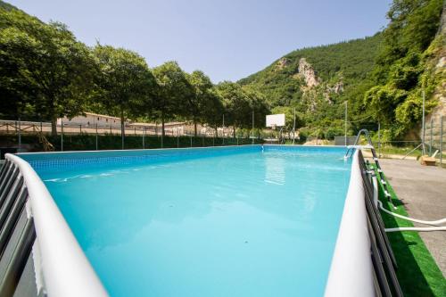 a large swimming pool with blue water at Hotel Roccaporena & Margherita in Roccaporena