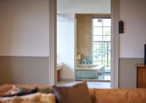 a living room with a couch and a view of a kitchen at GLAMDAY PORT in Atami