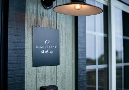 a sign on the side of a building with a window at GLAMDAY PORT in Atami