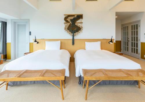 a bedroom with two beds and a table at GLAMDAY PORT in Atami