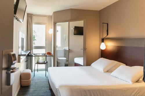 a hotel room with a bed and a bathroom at Kyriad Metz Centre - Restaurant Moze in Metz