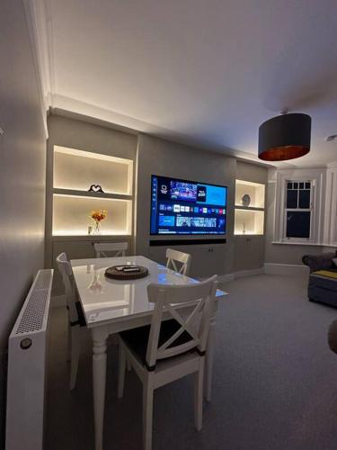 a living room with a table and chairs and a tv at Premium Apartment in Redhill Town Centre in Redhill