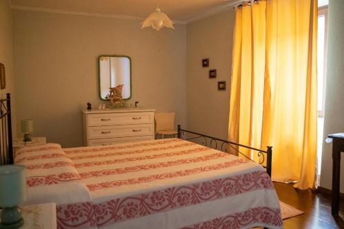 Schlafzimmer mit einem Bett, einer Kommode und einem Spiegel in der Unterkunft S'apposentu in Aritzo