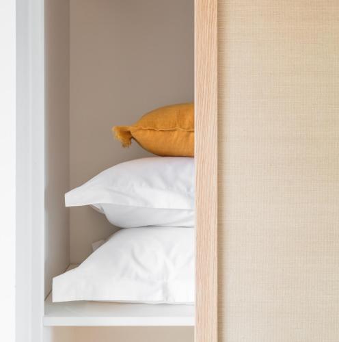 a stack of white pillows on a shelf at Mason & Fifth, Bermondsey in London