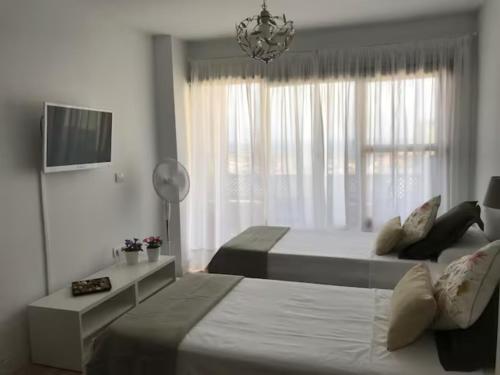 een hotelkamer met twee bedden en een raam bij Mirador del Atlántico - Aptos Tosca in Puerto de la Cruz