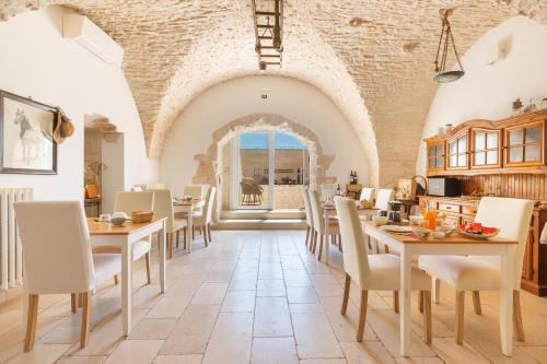 a kitchen and dining room with tables and chairs at Masseria Nicola Casavola in Martina Franca