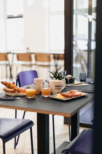 a table with breakfast foods and orange juice on it at Kyriad Metz Centre - Restaurant Moze in Metz