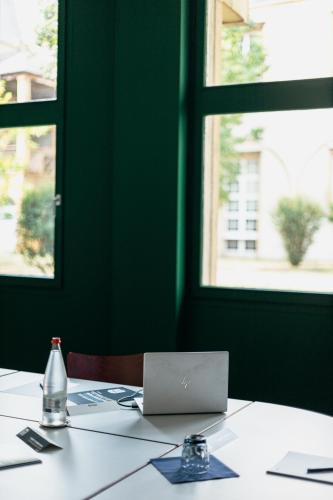a table with a laptop computer on top of it at Kyriad Metz Centre - Restaurant Moze in Metz